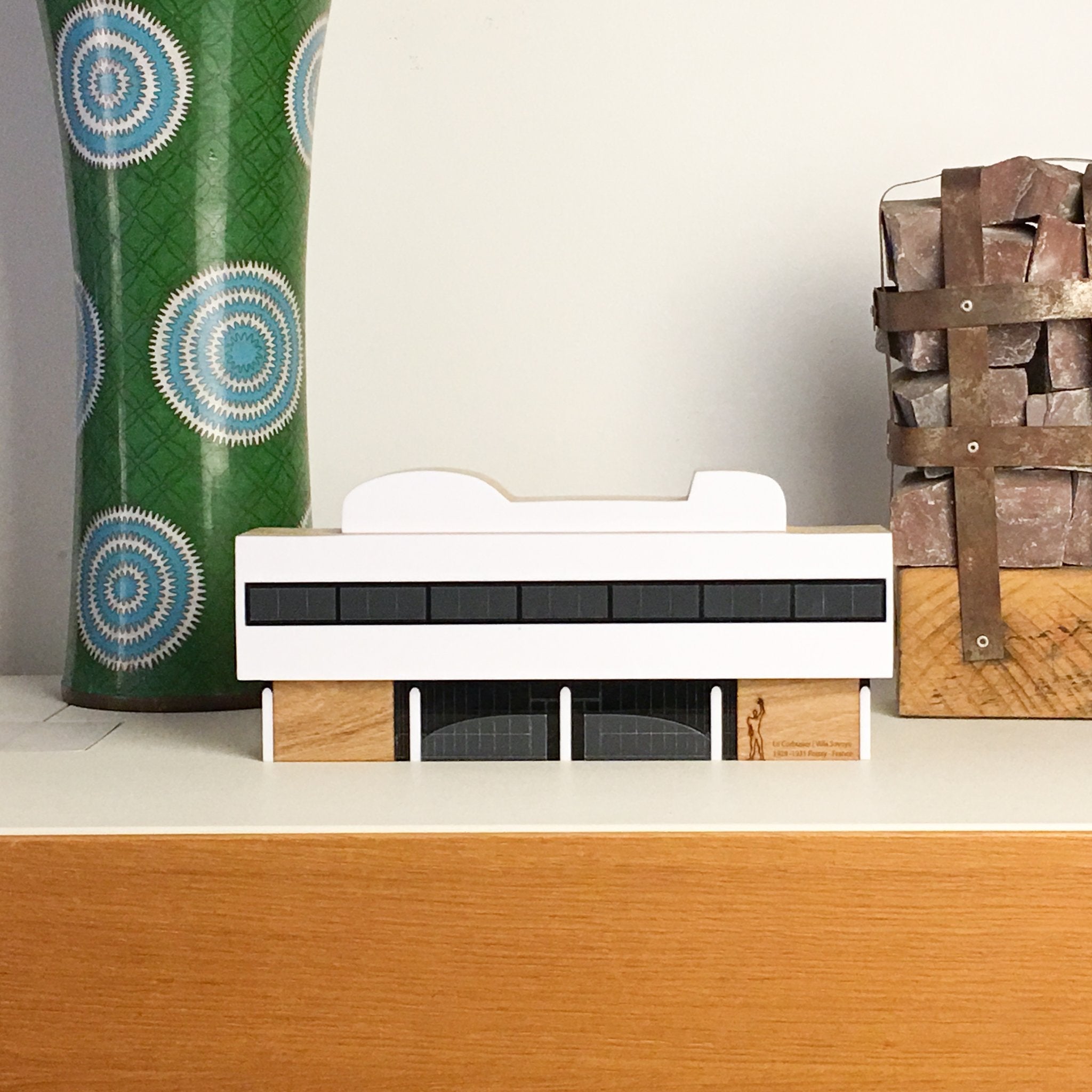 Miniatura da fachada da casa Villa Savoye projeto de Le Corbusier, feita em madeira e acrílico, em cima de aparador moderno vitra
